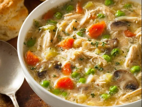 Delicious homemade chicken pot pie soup in a bowl with fresh ingredients.