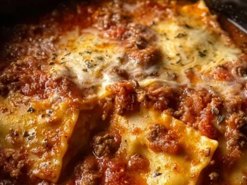 Delicious Crockpot Ravioli Lasagna served in a ceramic dish with melted cheese.