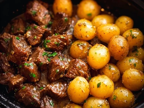Delicious Garlic Butter Beef Bites served with potatoes on a plate.