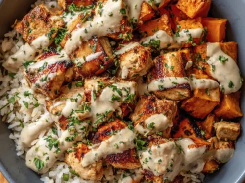 Healthy chicken and sweet potato rice bowl with colorful vegetables