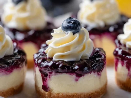 Healthy mini lemon blueberry cheesecakes served on a decorative plate.