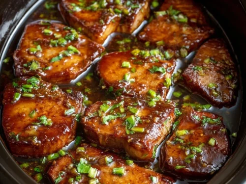 Slow cooker honey garlic pork chops served on a plate.