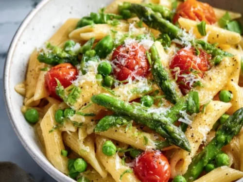 A bowl of spring vegetable pasta with colorful fresh vegetables