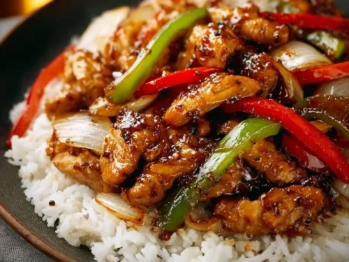 Delicious easy black pepper chicken served with vibrant peppers on a plate.